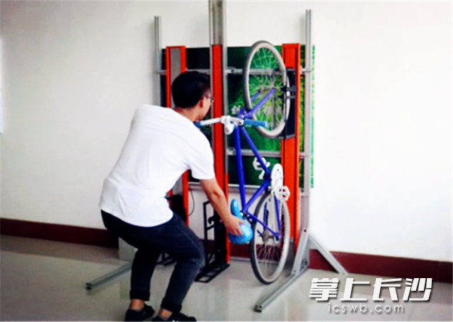 研发人员现场展示“翼停车”的立式停车装置。